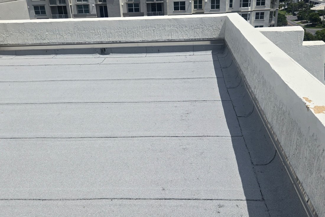 Low-slope roof deck and parapet edge on a South Florida oceanfront high-rise